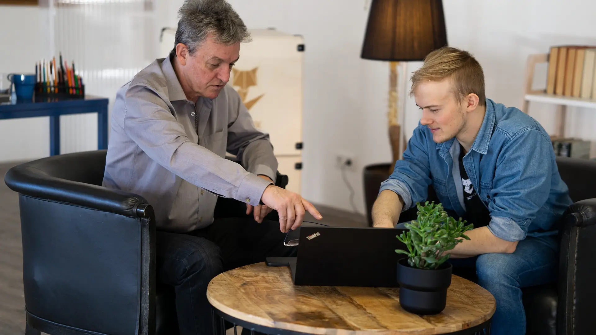 Mitarbeiter und Kunde in Besprechung vor Computer